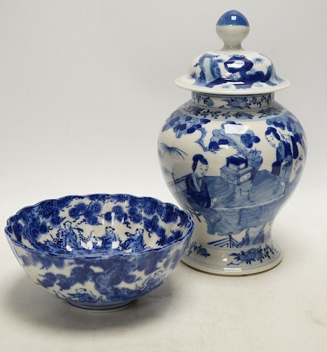 An early 20th century Chinese blue and white porcelain vase and cover decorated with figures in a landscape and a Japanese circular bowl, tallest 23cm. Condition - good